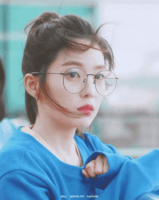 a girl wearing glasses and a blue sweater with bell redvelvet capture