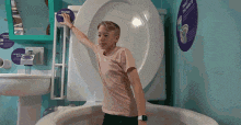 a young girl is sitting in a bathtub in front of a toilet .