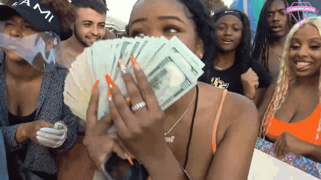 a woman covering her face with a bunch of money
