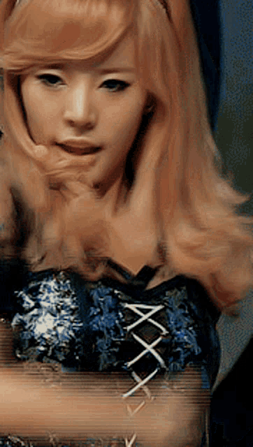 a woman with blonde hair is wearing a blue dress with a lace up front