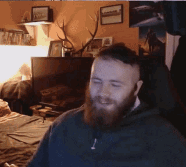 a man with a beard is sitting in front of a computer monitor