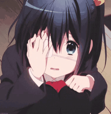 a girl with black hair and green eyes is covering her eye with her hands