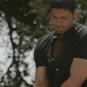 a man in a black shirt is looking down