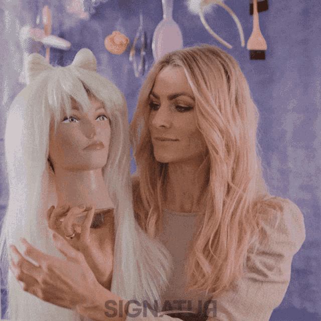 a woman standing next to a mannequin with signature written on the bottom of her shirt
