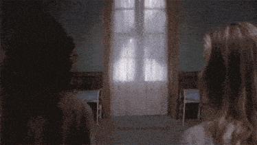 a girl is looking at a man in a white robe in a room