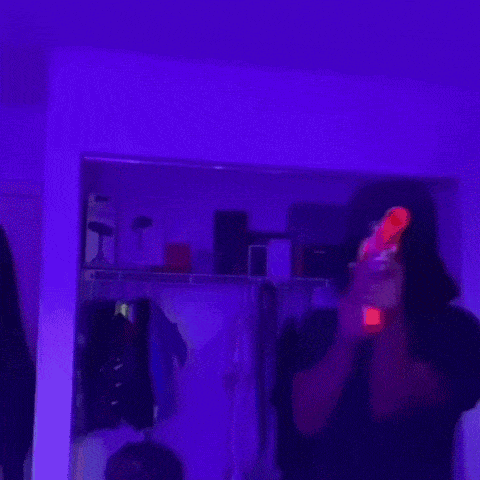 a woman is standing in a room with purple lights .