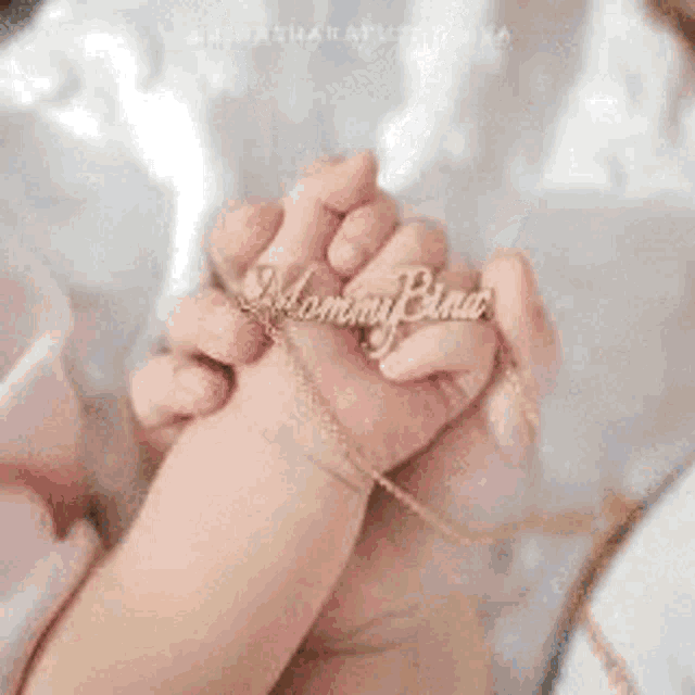 a woman is wearing a necklace with the name pauline and stars .