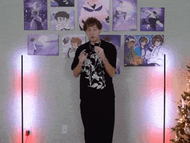 a man in a black shirt stands in front of a wall of pictures
