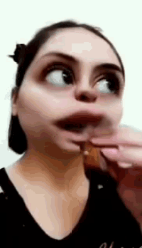 a woman is making a funny face while eating a piece of food