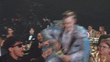 a man in a blue cape is holding a sword in his hand