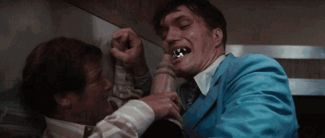 a man in a blue suit is biting another man