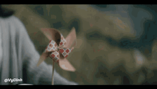 a person is holding an origami windmill in their hand with the words vydinh below it