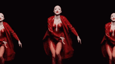 a woman in a red dress and red coat is dancing