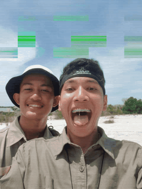 two young men are posing for a picture and one has a headband that says adidas