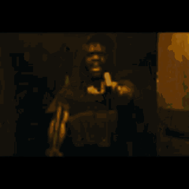 a man is standing in a dark room with a green light behind him .