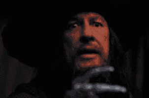 a man with long hair and a beard is wearing a hat and smoking a cigarette