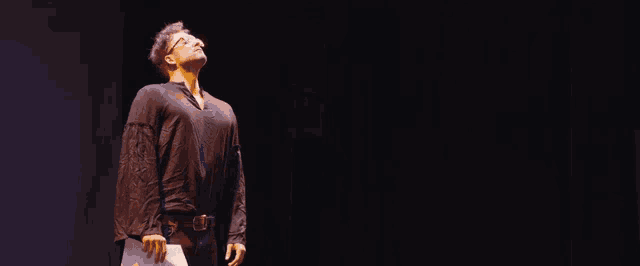 a man in a black shirt is standing on a stage