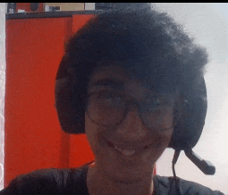 a young man wearing glasses and headphones smiles for the camera