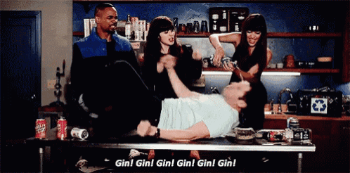 a group of people are standing around a man laying on a table with the words gin gin gin gin gin gin written on it .