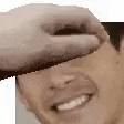 a person is covering a man 's face with their hand and smiling .