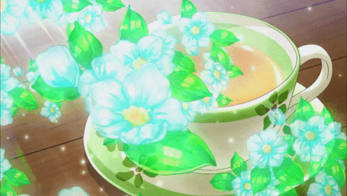 a cup of tea with blue flowers and green leaves
