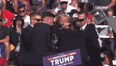 a man holding a sign that says " trump " on it