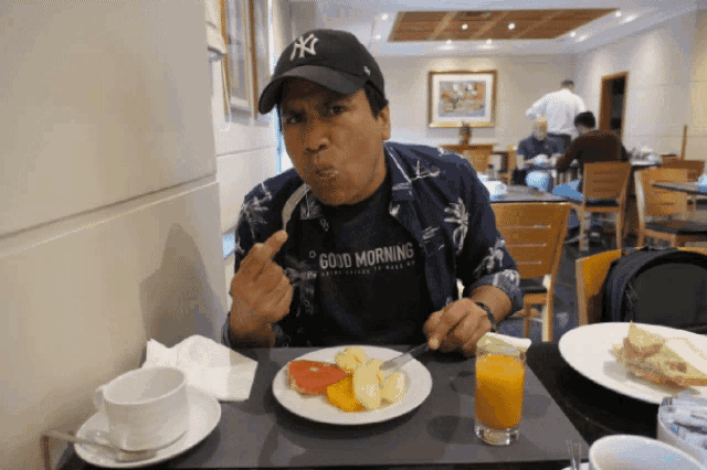 a man wearing a shirt that says good morning is eating