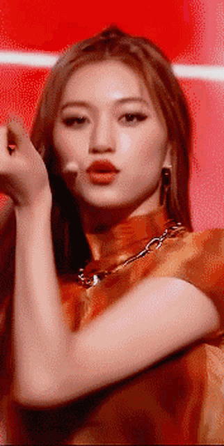 a close up of a woman 's face and arm with a red background .