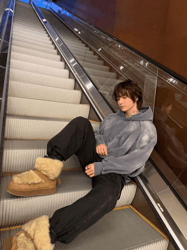 a person sitting on a set of stairs with a hoodie on