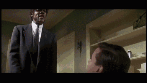 a man in a suit and tie talks to another man