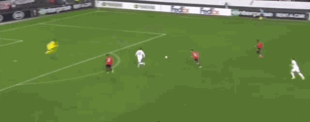 a soccer player is laying on his back on the field while kicking a soccer ball .
