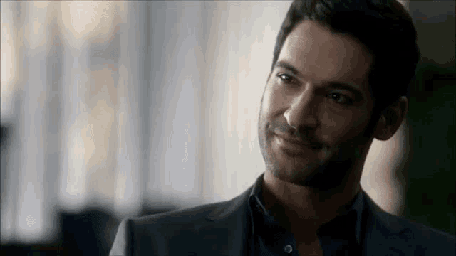 a close up of a man in a suit smiling .
