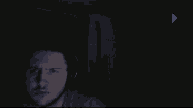 a shadow of a guitar is cast on a dark wall