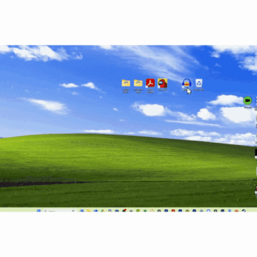 a computer screen with a green hill in the background and a bunch of icons