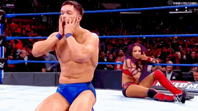 a man and a woman are wrestling in a ring .