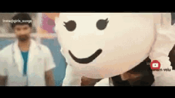 a man in a lab coat is standing next to a woman wearing a white mask with a smiling face on it .