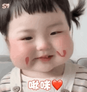 a baby girl with a heart drawn on her face is smiling .