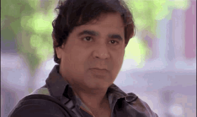 a man with a serious look on his face is wearing a black shirt .