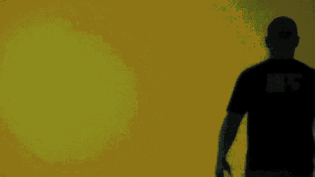 a silhouette of a man wearing a black shirt that says ' ec3 ' on the back