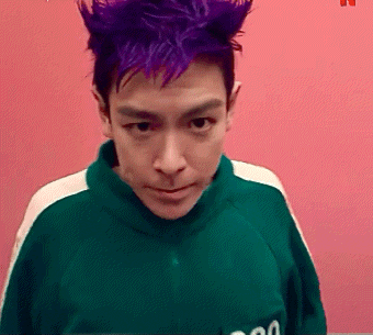 a man with purple hair is wearing a green shirt with the number 00 on the pocket