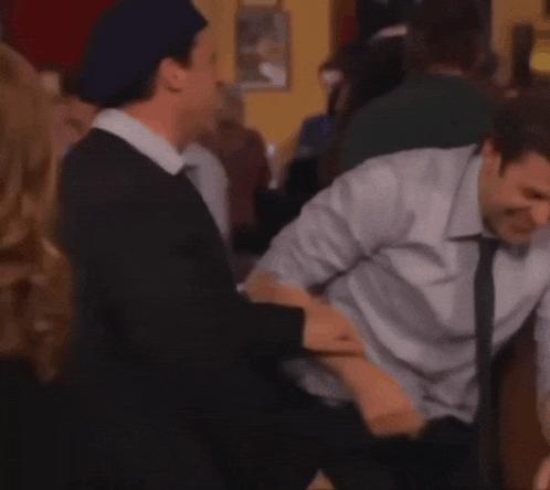 a group of people are laughing and having fun in a crowded room .