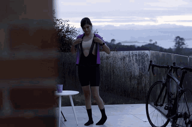 a woman is getting ready to ride a bike on a balcony