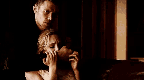 a man is holding a woman in his arms while she is crying .