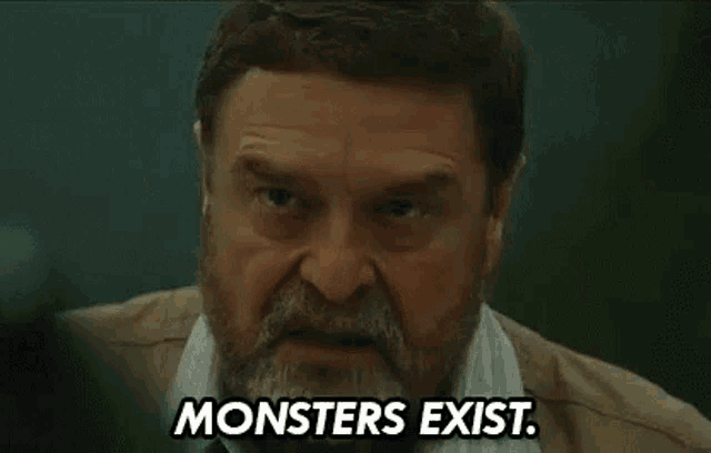 a man with a beard is making a funny face and says `` monsters exist '' .