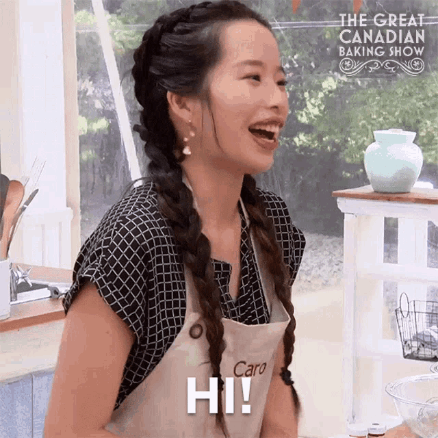 a woman wearing an apron that says caro on it is smiling and saying hi