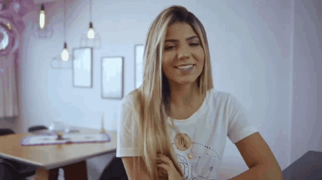 a woman wearing a white t-shirt with a virgo sign on it