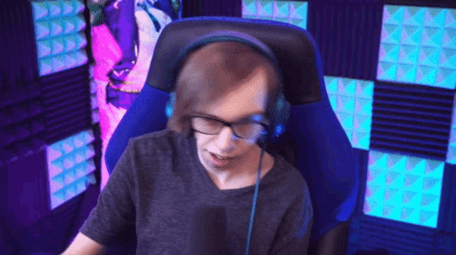 a person wearing headphones and glasses is sitting in a chair