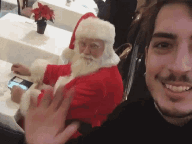 a man is taking a picture of himself with santa claus