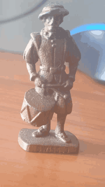a statue of a man holding a drum with the word knight on the bottom