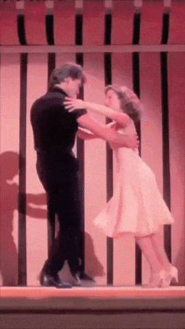 a man and a woman are dancing on a stage in front of a pink awning
